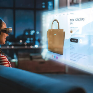 Nuori nainen käyttää virtuaalilaseja istuessaan kotona. ja tekemässä online ostoksia.