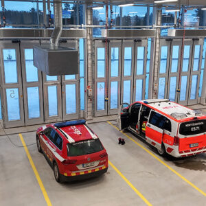 Kaksi pelastuslaitoksen autoa palolaitoksen hallissa.
