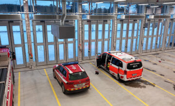 Kaksi pelastuslaitoksen autoa palolaitoksen hallissa.