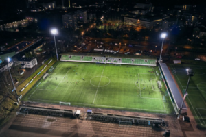 Kuvassa on Kotkan jalkapallokenttä kuvattuna ylhäältäpäin pimeään aikaan. Taustalla näkyy kaupungin valoja.